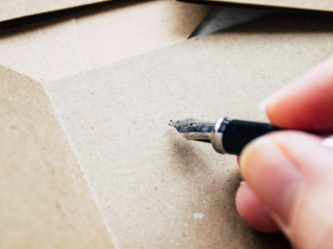 Close-up of hands signing a last will document with a fountain pen